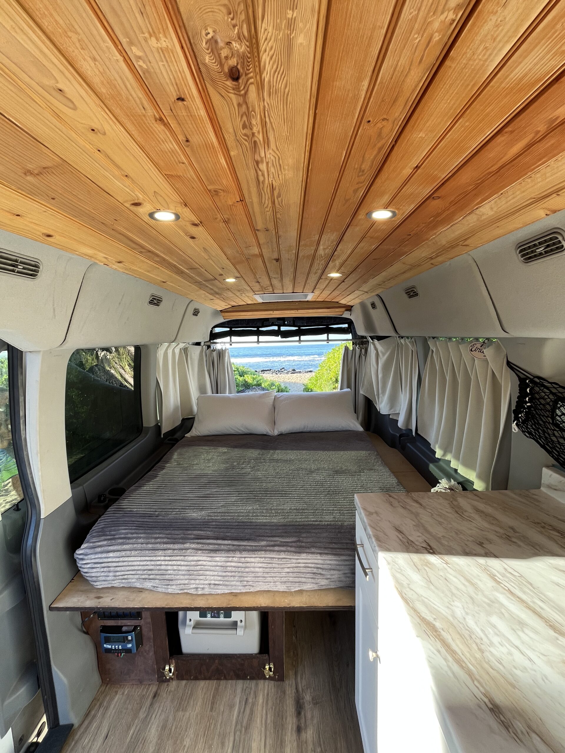 Carlos Camper Van – Long Bed Setup with Ambient Lighting Long bed setup inside Carlos camper van with soft lighting and organized storage
