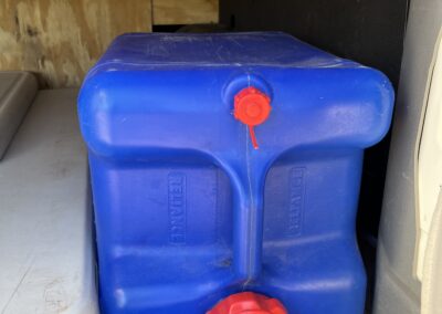 Reusable water container inside Carlos Vantana camper van for off-grid hydration.